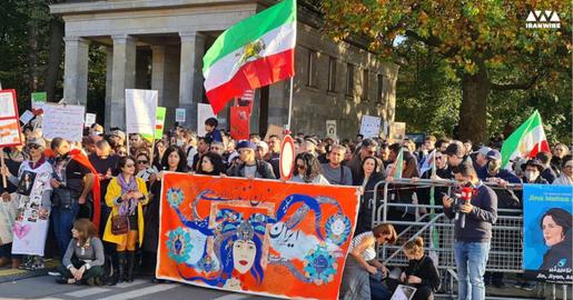 ۴: پلاکارد ایران با شعار زن، زندگی ، ازادی در دست حاضران در تجمع بزرگ برلین