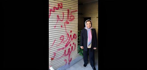 Shirin Ebadi next to an offensive graffiti reading “mercenary” was sprayed on the wall of her home in Tehran