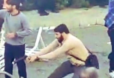 یک لباس شخصی در کنار دیگر ماموران لباس شخصی در یکی از تجمعات اعتراضی در دانشگاهی در تهران به سمت افراد شلیک می‌کند