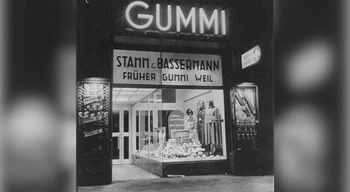 این عکس از یک مغازه‌ متعلق به یک خانواده یهودی (Gummi Weil) گرفته شده است که در روند «آریایی کردن» کسب‌وکارهای یهودیان مصادره، و به یک خانواده غیریهودی (Stamm and Bassermann) واگذار شد.