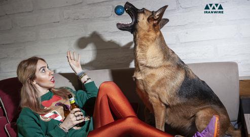 Young woman playing with a dog after a photo shooting on June 2, 2020.