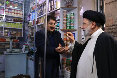 The picture showing Faizollah Qaderi, a shopkeeper at Sanandaj’s bazar, welcoming President Ebrahim Raisi was widely published in government-affiliated media.