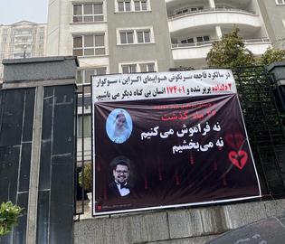 کندن بنر یادبود جانباختگان هواپیمای اوکراینی توسط لباس شخصی‌ها