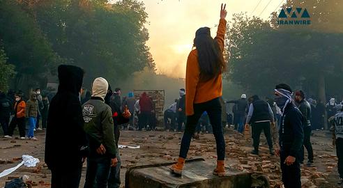 در جریان اعتراضات سراسری ۱۴۰۱ دختری بدون حجاب اجباری در کنار دیگر معترضین که خیابان را بسته‌اند، علامت پیروزی را نشان می‌دهد. بوکان، آذربایجان غربی