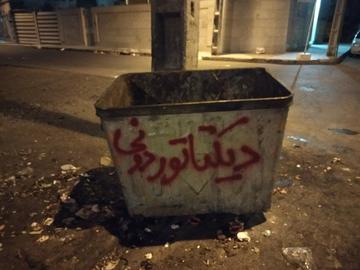 تصویری از شعار نویسی روی سطل آشغال در زاهدان