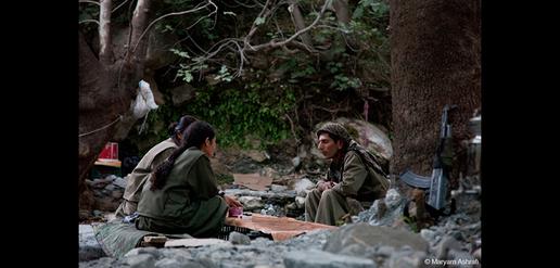 Three Kurdish fighters plan their day in the camp in the heart of the mountains.