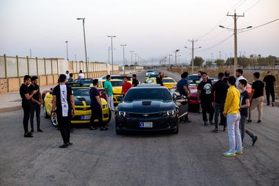 A gathering of young Iranian men with an interest in American cars