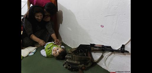 Kohistan kisses her mother, who is changing her one-year-old brother Fouad’s diaper. 