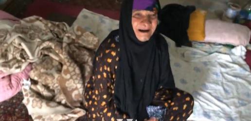 این زن، زیر عکس خامنه‌ای و خمینی با فقر زندگی می‌کند