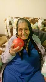 A photo of Nima Ghadiri's grandmother holding a pomegranate on Shab-e Yalda (An ancient Persian festival commemorating the Winter Solstice), three weeks before she died
