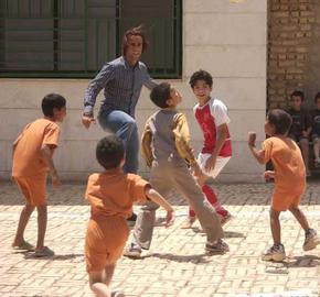 علی کریمی در حال بازی با بچه‌های یک روستا