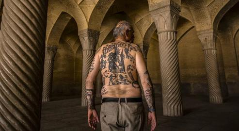 An Iranian elderly man shows off his tattoos in Vakil Mosque, Shiraz
