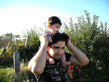 Amir holding his nephew at an apple orchard