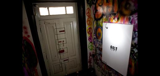 The entrance to the exhibition is labeled “Safe House” but has four painted locks.