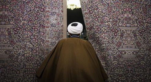 An Iranian cleric enters the Eighth Imam Shiite shrine in Mashhad, Iran