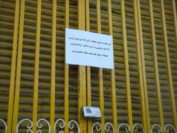 Sign announcing the closure of a Baha'i business
