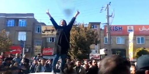زنی ایستاده بر روی سقف یک اتومبیل در میان مردم معترض در شهر بوکان در آذربایجان‌ غربی در حالی که دست‌هایش را بالا گرفته بود، با دستانش علامت پیروزی نشان می‌داد