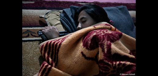 Parisa, a 22-year-old fighter, sleeps after a long day of military training.