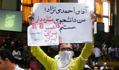 A protester holds a sign saying "Mr Ahmadinejad, I am a star student"