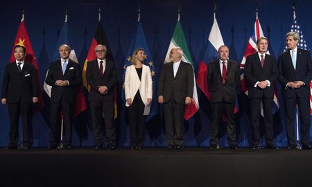 Nuclear deal negotiators stand behind their flags.