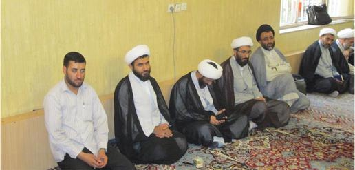 A cleric texts during a meeting with a grand ayatollah