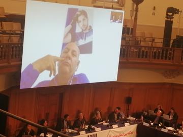 At the Aban Tribunal in London, Amin Ansarifard indicates where the bullet exited his son Farzad's face on November 16, 2019