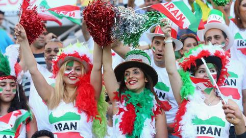 Iranian women and men cheer their national team during the Asian Cup 