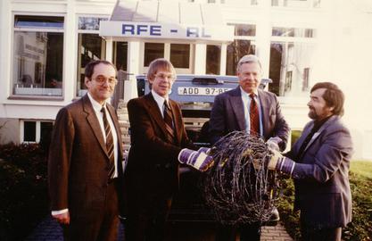 RFE Director A. Ross Johnson (center left) with a piece of the Iron Curtain