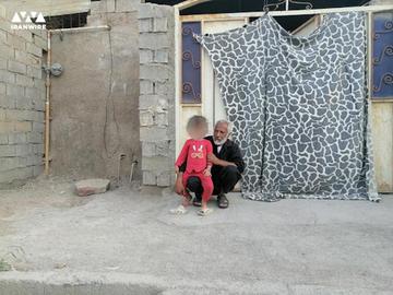 پدر «کریم بندری» همراه با دختر چهارساله او مقابل خانه‌شان