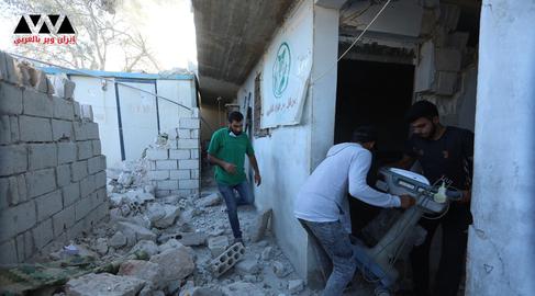رجالا يعملون على إخراج مستلزمات طبية من النقطة الطبية التي دمرت بفعل القصف المدفعي
